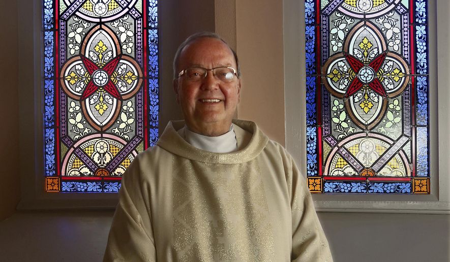 In this May 16, 2017 photo, Monsignor Michael Kuse, longtime pastor of Blessed Sacrament Parish poses for photo at the church in Quincy, Ill. Use is retiring from the priesthood June 30. Monsignor Kuse has spent 50 years as a priest. (Michael Kipley/The Quincy Herald-Whig via AP)