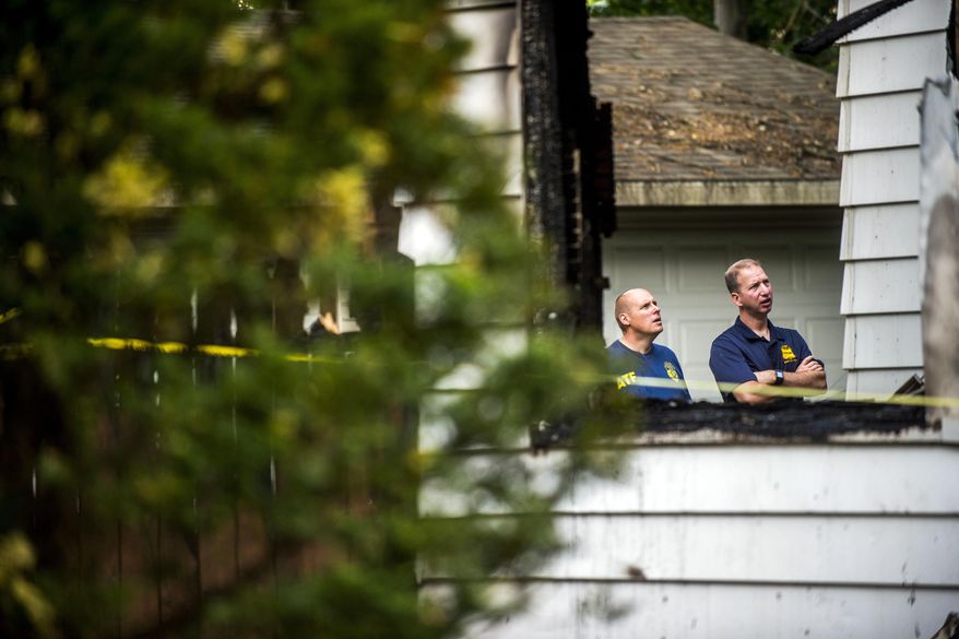 Michigan State Police fire investigators work to find the cause of an early morning blaze that claimed three lives on Monday, June 12, 2017, in Flint, Mich.  (Jake May /The Flint Journal-MLive.com via AP)