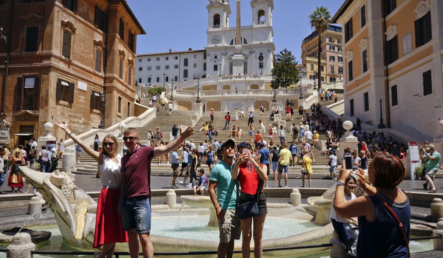 People pose for photos in front of Italian sculptor Bernini's Barcaccia fountain, just next to the Spanish steps, in Rome, Monday, June 12, 2017. City hall on Monday announced that Mayor Virginia Raggi had signed an ordinance aimed at protecting some 40 fountains of historic or artistic interest to try to protect the monumental works, not infrequently trashed by tourists, sports fans and Romans. (AP Photo/Andrew Medichini)