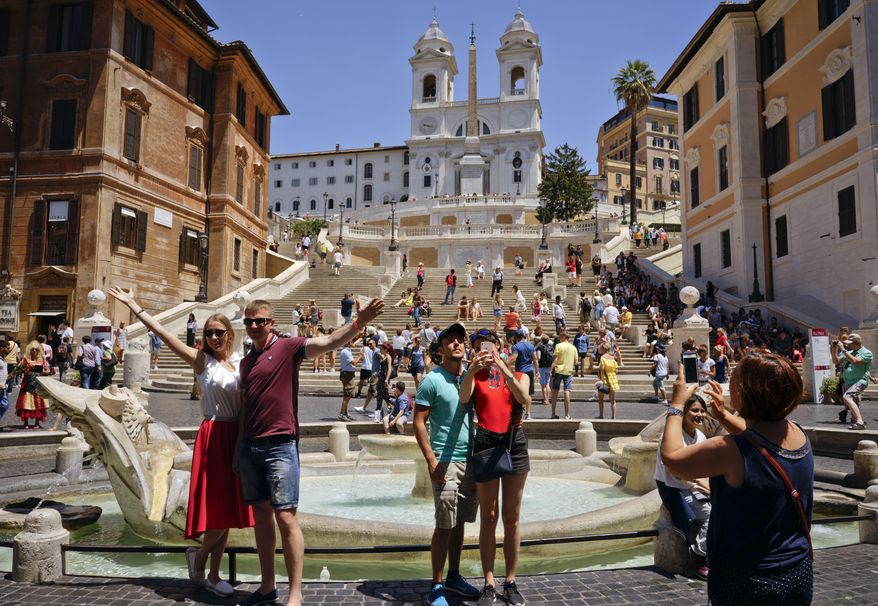 People pose for photos in front of Italian sculptor Bernini's Barcaccia fountain, just next to the Spanish steps, in Rome, Monday, June 12, 2017. City hall on Monday announced that Mayor Virginia Raggi had signed an ordinance aimed at protecting some 40 fountains of historic or artistic interest to try to protect the monumental works, not infrequently trashed by tourists, sports fans and Romans. (AP Photo/Andrew Medichini)