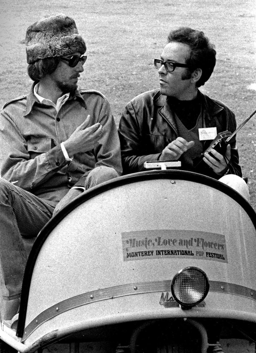 ADVANCE FOR USE TUESDAY, JUNE 13, 2017 AND THEREAFTER-In this June 16, 1967 photo, co-producer John Phillips, left, talks with Alan Pariser, right, at the Monterey Pop Festival in Monterey, Calif. Phillips of The Mamas &amp;amp; the Papas came up with the idea for three days of music with proceeds going to charitable causes. He brought in Grammy-winning record producer Lou Adler, promoter Alan Pariser and publicist Derek Taylor, who worked with the Beatles. (Monterey Herald via AP)