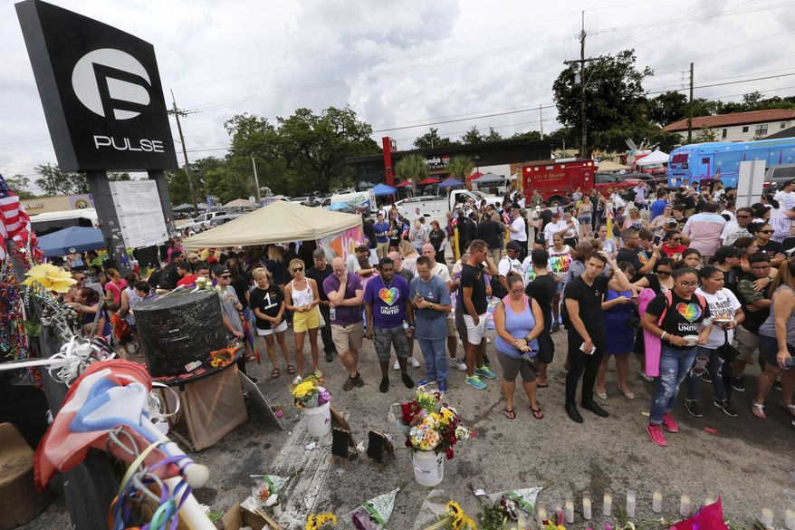 People gather during a community gathering at the Pulse nightclub memorial site in Orlando, Fla., Monday, June 12, 2017. A gunman opened fire at the nightclub one year ago in the worst mass shooting in modern U.S. history, killing 49 people. (Joe Burbank/Orlando Sentinel via AP)