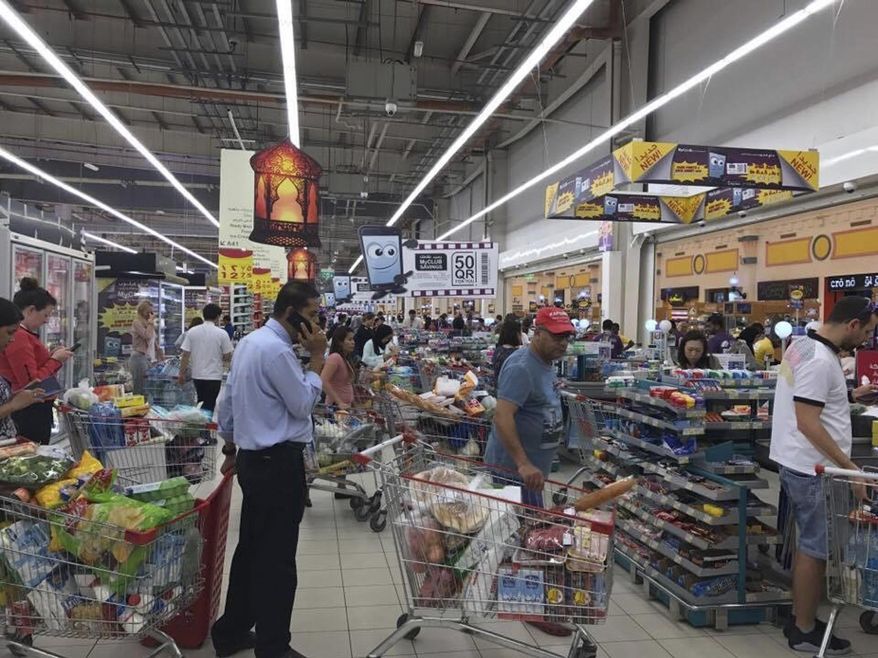 FILE -- In this Monday, June 5, 2017 file photo, provided by Doha News, shoppers stock up on supplies at a supermarket in Doha, Qatar after Saudi Arabia closed its land border with Qatar, through which the tiny Gulf nation imports most of its food. Qatar said Monday, June 12, 2017, that it had begun shipping cargo through Oman to bypass Gulf countries that have cut off sea and land routes to the tiny, energy-rich nation, the latest move by Doha to show it can survive a diplomatic dispute with its neighbors. (Doha News via AP, File)