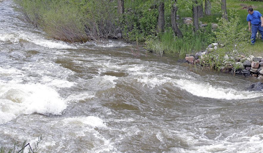 FILE - This Wednesday, May 31, 2017, file photo, Ron Lenfield watches the fast-flowing Weber River along his property, in Oakley, Utah. Rivers in Utah are expected to remain dangerously swollen with icy mountain runoff for several more weeks. (AP Photo/Rick Bowmer, File)