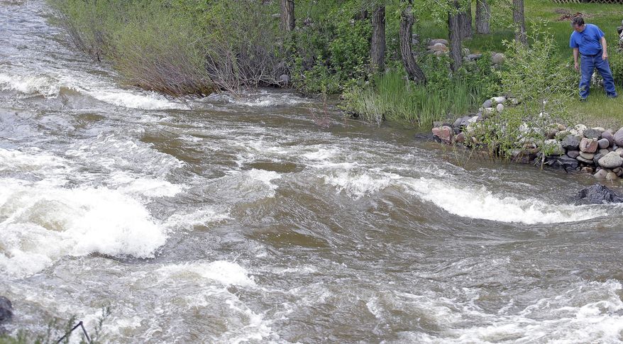 FILE - This Wednesday, May 31, 2017, file photo, Ron Lenfield watches the fast-flowing Weber River along his property, in Oakley, Utah. Rivers in Utah are expected to remain dangerously swollen with icy mountain runoff for several more weeks. (AP Photo/Rick Bowmer, File)
