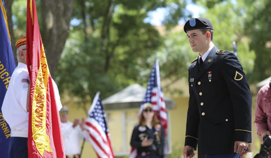 Army reservist Harland Fletcher walks on stage to receive his high school diploma during a private graduation ceremony Monday, June 12, 2017, in Brentwood, Calif. The Liberty High School principal held the ceremony as an apology for not allowing Fletcher to wear his military uniform during his graduation last Friday. (AP Photo/Linda Wang)
