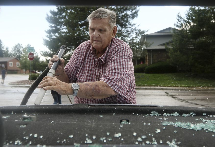Bill Jones vacuums out the shattered glass from the back window of his granddaughters vehicle at the intersection of Gardenia Drive and Cordova Drive on Monday, June 12, 2017, near Carpenter, Wyo. Severe storms spawned tornadoes and dropped large hail in parts of eastern Wyoming, injuring at least one person. (Blaine McCartney/The Wyoming Tribune Eagle via AP)