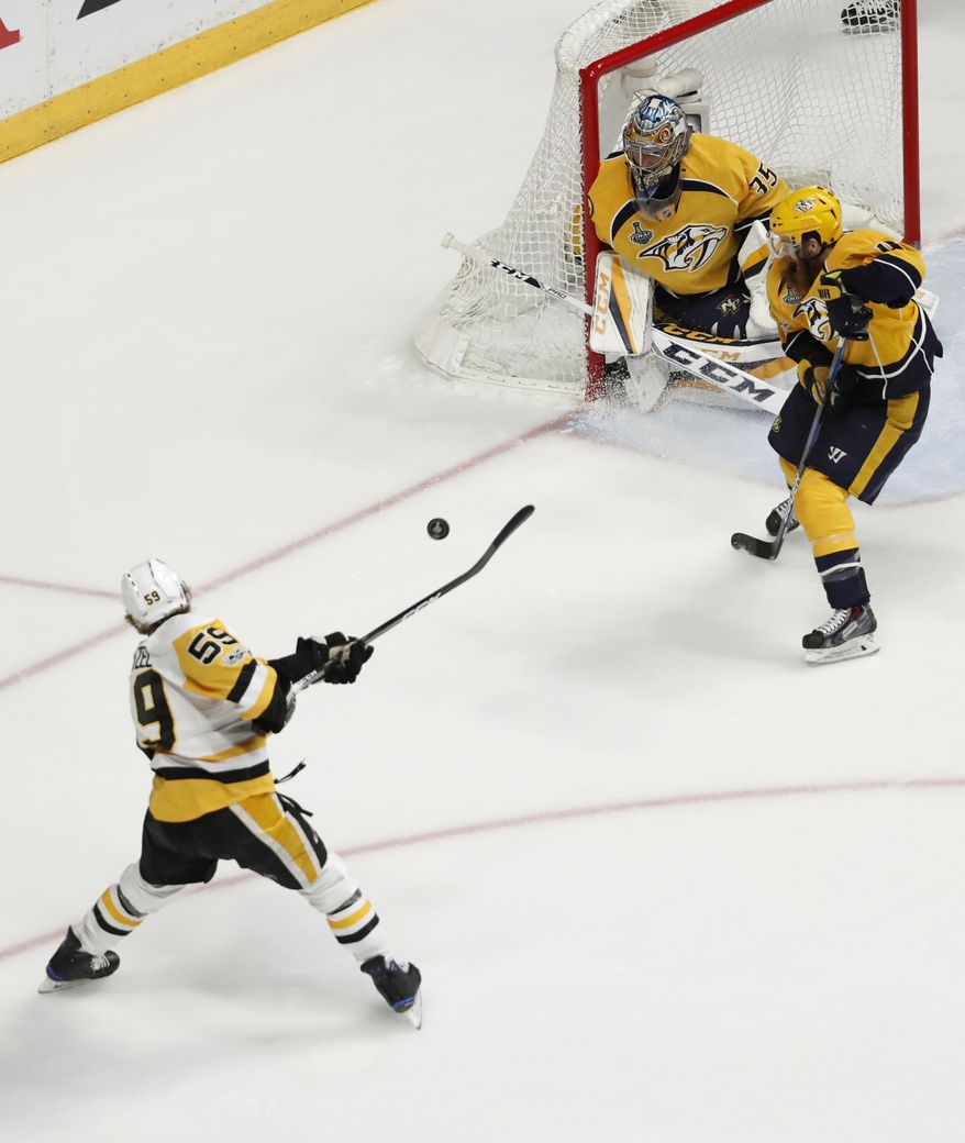 Pittsburgh Penguins&#x27; Jake Guentzel (59) shoots as Nashville Predators goalie Pekka Rinne (35), of Finland, defends the goal during the first period of Game 6 of the NHL hockey Stanley Cup Final, Sunday, June 11, 2017, in Nashville, Tenn. (AP Photo/Jeff Roberson)
