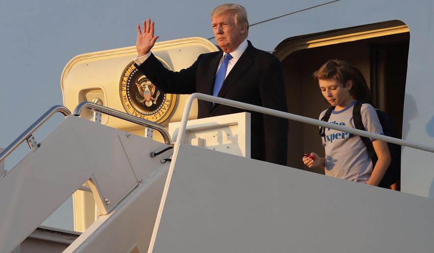 President Donald Trump waves in front of his son Barron as he steps off Air Force One after arriving at Andrews Air Force Base, Md., Sunday, June 11, 2017. Trump was returning to Washington after spending the weekend at Trump National Golf Club in Bedminster, N.J. (AP Photo/Patrick Semansky)