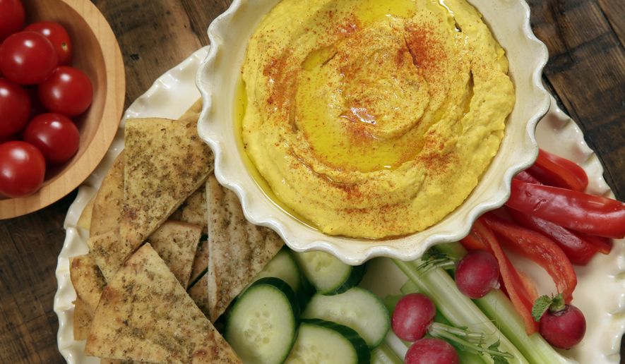 FILE - This Jan. 20, 2017, file photo shows roasted carrot hummus with crudite and pita chips at the Institute of Culinary Education in New York. In an experiment at a Stanford University cafeteria, researchers got more diners to choose vegetables by using fancy-sounding names instead of using labels like low-fat, reduced-sodium or sugar-free. (AP Photo/Richard Drew, File)