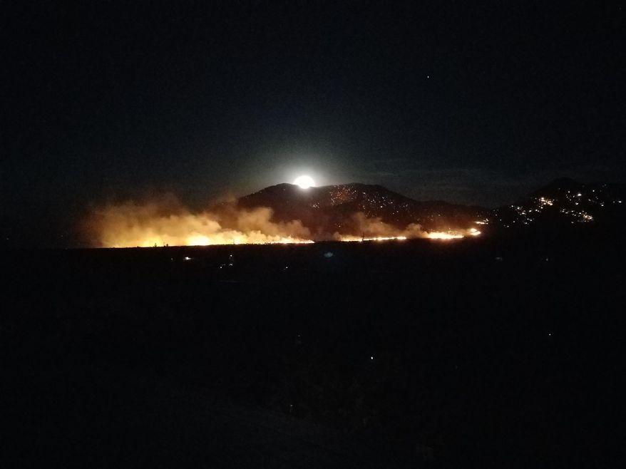 In this Saturday, June 10, 2017, photo provided by Heather Floyd, a wildfire burns in Dragon, Ariz. Over two dozen wildfires tore through dry and windy Arizona on Monday, June 12, drawing crews from across the Western United States to the state with the most blazes burning in the nation. (Heather Floyd via AP)