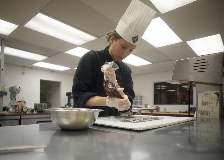 In this undated photo chocolate chef Audrey Polloni makes chocolates at Michel Cluizel's Chocolatrium in West Berlin, N.J. Nearly all of the recipes made by hand in the French chocolate company's West Berlin factory are dairy-free, many are gluten-free and, with the exception of two pastries — eclairs and macarons — are vegan, according to Jacques Dahan, the president of Michel Cluizel USA. (Jose F. Moreno/Camden Courier-Post via AP)