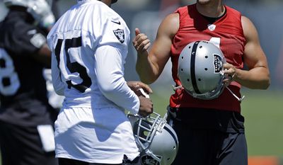 Oakland Raiders quarterback Derek Carr, right, speaks with wide receiver Michael Crabtree (15) during NFL football practice on Tuesday, June 13, 2017, at the team&#39;s training facility in Alameda, Calif. (AP Photo/Ben Margot)