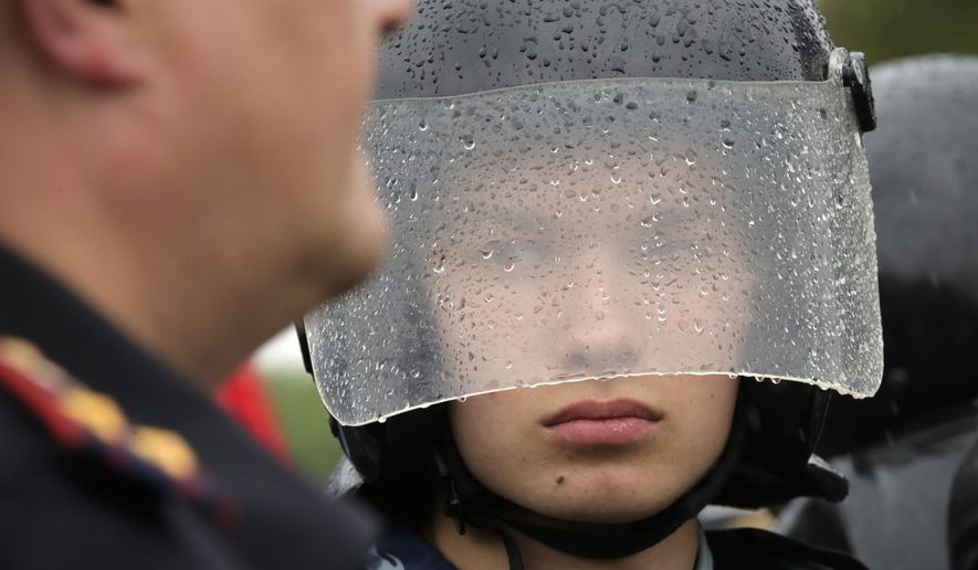 A policeman stands in the rain during anti corruption rally in St.Petersburg, Russia, Monday, June 12, 2017. The protest gatherings in cities from Far East Pacific ports to St. Petersburg were spearheaded by Alexei Navalny, the anti-corruption campaigner who has become the Kremlin's most visible opponent. (AP Photo/Dmitri Lovetsky)