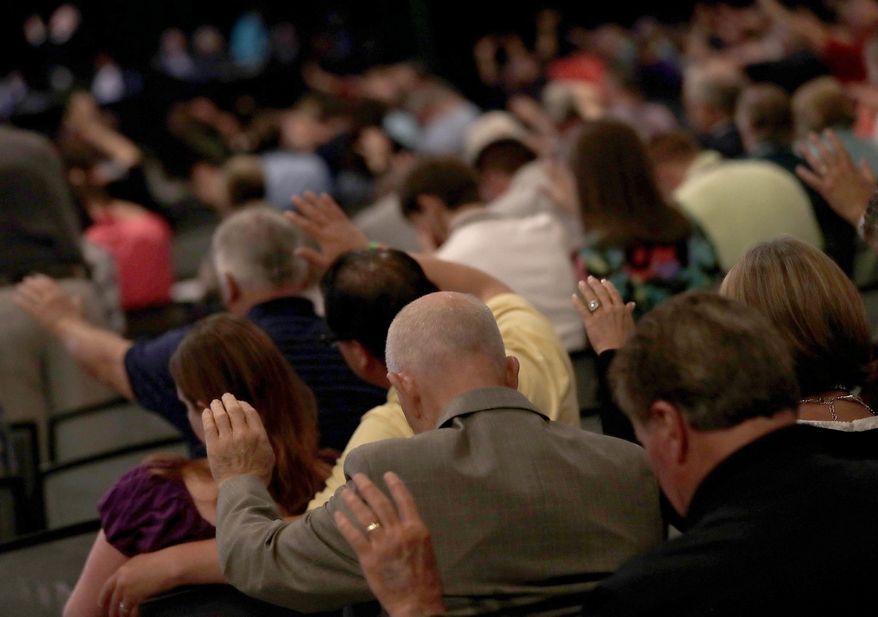People pray during the Southern Baptist Convention annual meeting, Tuesday, June 13, 2017, in Phoenix. (AP Photo/Matt York)