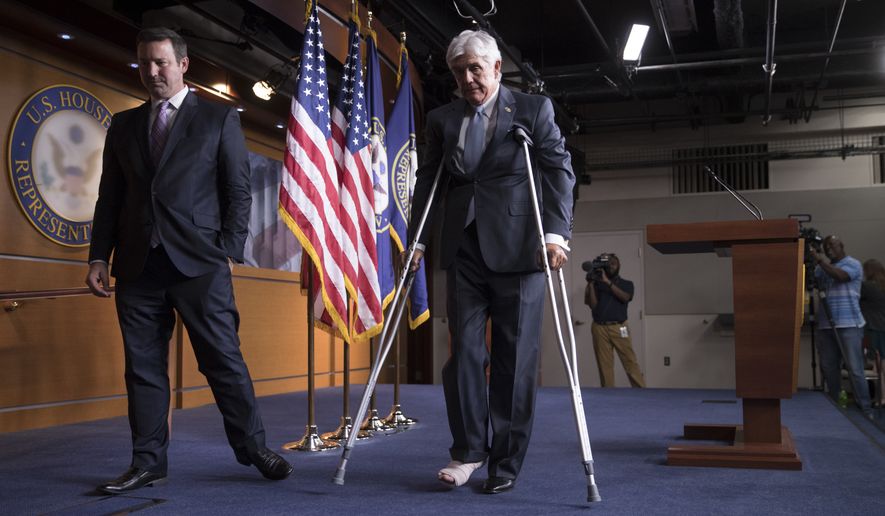 Rep. Roger Williams, R-Texas, who injured his ankle during a shooting at a congressional baseball game practice, leaves a news conference on crutches, assisted by his aide J. Spencer Freebairn, left, at the Capitol in Washington, Wednesday, June 14, 2017. (AP Photo/J. Scott Applewhite)