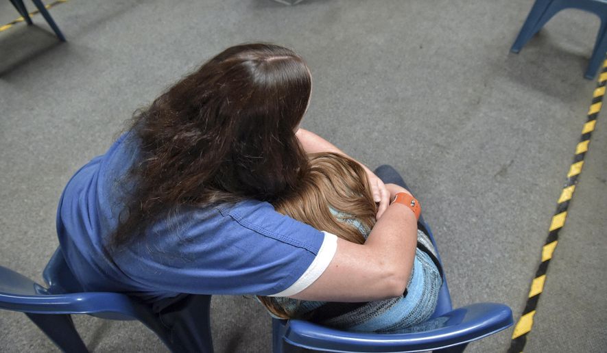 Inmate Ashley and her daughter hug in the visitation room at Lancaster County, Pa., Prison on June 1, 2017 . During special visits arranged by the family services advocate, parents and children don't have to be separated by the yellow line that normally divides inmates from visitors. (Dan Marschka /LNP via AP)