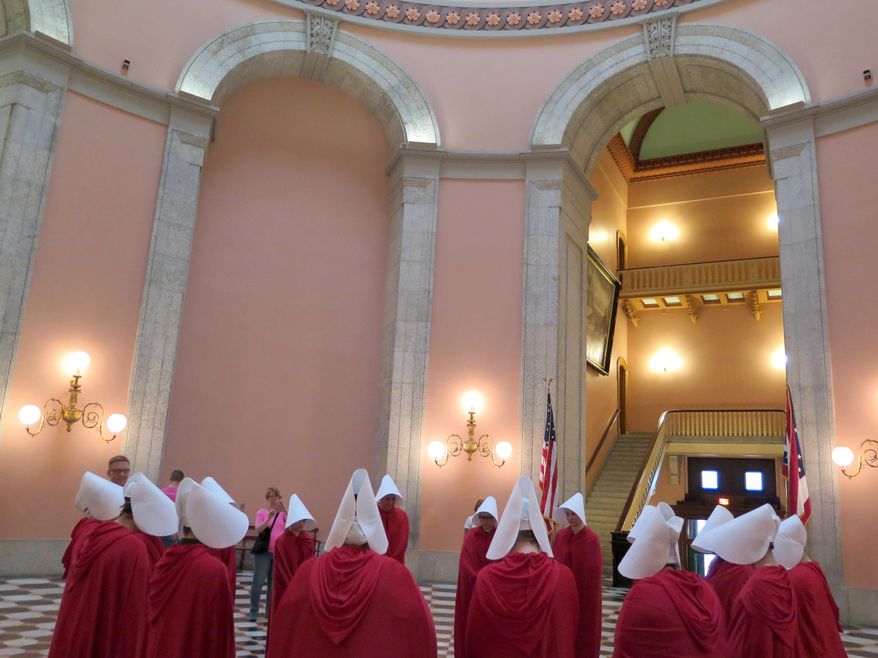 In this Tuesday, June 13, 2017 photo, women dressed in character from the dystopian novel &amp;quot;The Handmaid&#x27;s Tale&amp;quot; stage a protest in the Ohio Statehouse Rotunda, in Columbus, against a bill criminalizing the state&#x27;s most common abortion procedure. (Jo Ingles/Ohio Public Radio/TV)
