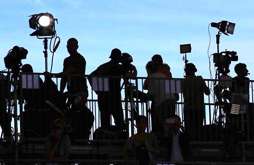 Reporters and photographers on the watch at a press stakeout. Analysts worry about the caustic headlines that often follow. (Associated Press)