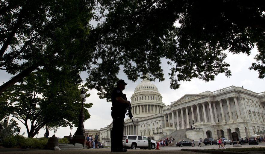 A Capitol Hill Police officer scans the area on Capitol Hill in Washington, Wednesday, June 14, 2017, after House Majority Whip Steve Scalise of La. was shot during during a congressional baseball practice in Alexandria Va. (AP Photo/Jose Luis Magana)