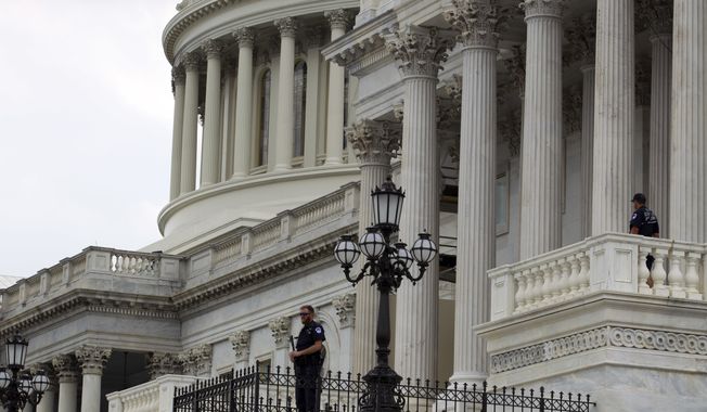 Capitol Hill Police officers scan the area on Capitol Hill in Washington, Wednesday, June 14, 2017, after House Majority Whip Steve Scalise of La. was shot during during a congressional baseball practice in Alexandria Va. (AP Photo/Jose Luis Magana)