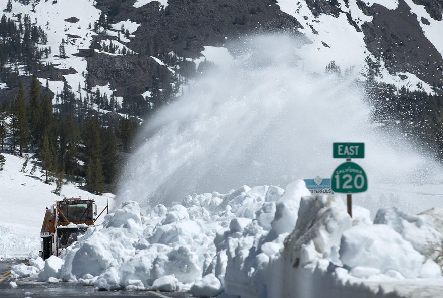 In this photo taken Tuesday, June 6, 2017, a Caltrans rotary blower clears snow from Highway 120 near Yosemite National Park, Calif. This year's heavy snowfall has crews working to clear Highway 120, the only road through Yosemite that connects the Central Valley on the west side with the Owens Valley on the east side of the Sierra Nevada. Crews are working to remove snow from roads through two national parks as summer approaches. (AP Photo/Rich Pedroncelli)