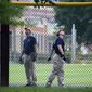 A FBI lab team looks for evidence in the outfield signage at the ball field which is the scene of a multiple shooting in Alexandria, Va., Wednesday, June 14, 2017, after a rifle-wielding attacker opened fire on Republican lawmakers at a congressional baseball practice, wounding House GOP Whip Steve Scalise of Louisiana and several others as congressmen and aides dove for cover. (AP Photo/Cliff Owen)