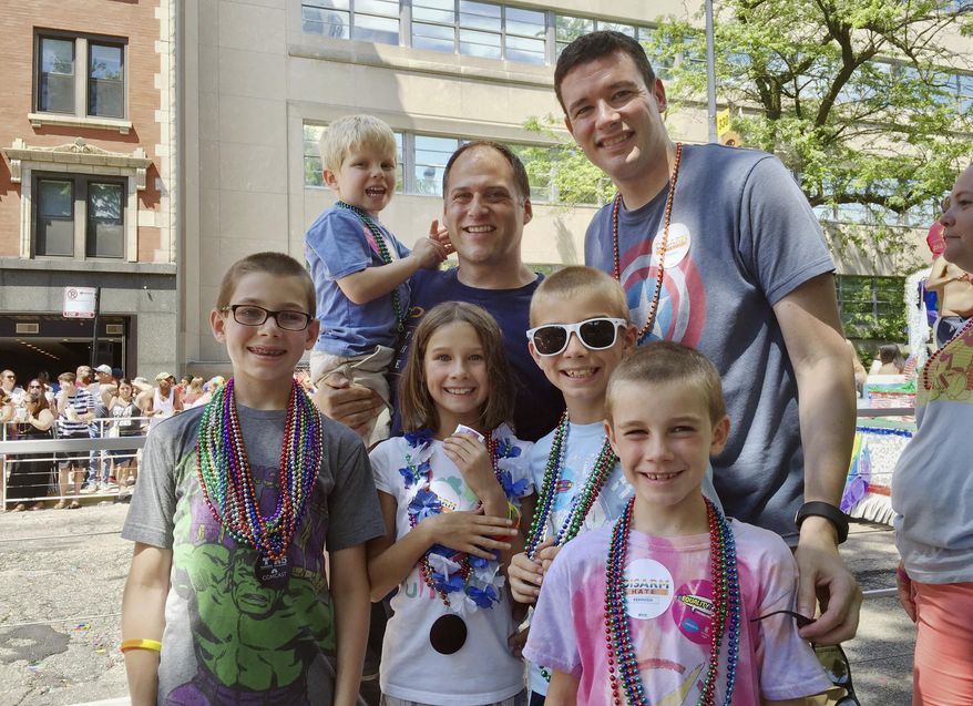 ADVANCE FOR USE SUNDAY, JUNE 18, 2017 AND THEREAFTER-This June 26, 2016 photo provided by the family shows Kevin Neubert, background center, and Jim Gorey with their adopted children, from left, Luke, Derek, Natalie, Zach, and Jacob at the Chicago Pride Parade. Following night classes to qualify as foster parents, Neubert and Gorey agreed in December 2011 to provide a temporary home for a newborn baby. A stay intended to last only for a few days was extended into several months, and Neubert and Gorey learned that the baby had four older siblings who were also in foster care. They eventually decided to adopt all five. (Nicole Gifford Baugh/Jim Gorey via AP)