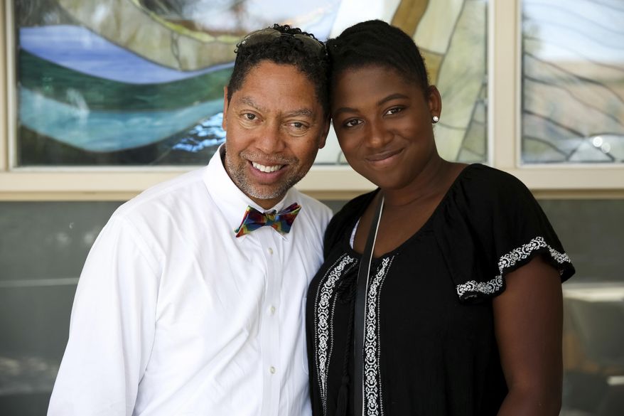 ADVANCE FOR USE SUNDAY, JUNE 18, 2017 AND THEREAFTER-This April 22, 2017 photo provided by Dylan Perot shows Dr. Christopher Harris, a Los Angeles-based pediatrician, and his daughter Maria, 14, whom he adopted as an infant, at an LGBT families event Los Angeles. For more than a year, he worked with a church-affiliated adoption agency, taking parenting classes, submitting to home visits. Yet his application never progressed, and he finally deduced that it was because he was gay. He reached another dead end with a second agency. "It was frustrating for me to get passed over," Harris said. "As a pediatrician, I look at the science and see there are no data that children raised by gay and lesbian parents don't do well." (Dylan Perlot via AP)