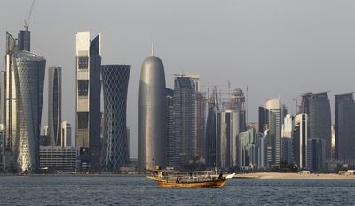 FILE - In this Thursday Jan. 6, 2011 file photo, a traditional dhow floats in the Corniche Bay of Doha, Qatar, with tall buildings of the financial district in the background. Qatar says it has pulled all of its troops from the border of Djibouti and Eritrea, East African nations that have a long-running territorial dispute which Doha had helped mediate. (AP Photo/Saurabh Das, File)
