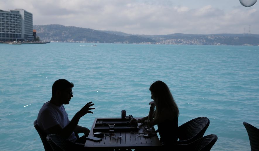 People play backgammon in a coffee shop by Istanbul's Bosphorus Strait, Wednesday, June 14, 2017. Turkish media report a significant part of the Black Sea and the Bosphorus has turned turquoise due to phytoplankton.(AP Photo/Lefteris Pitarakis)