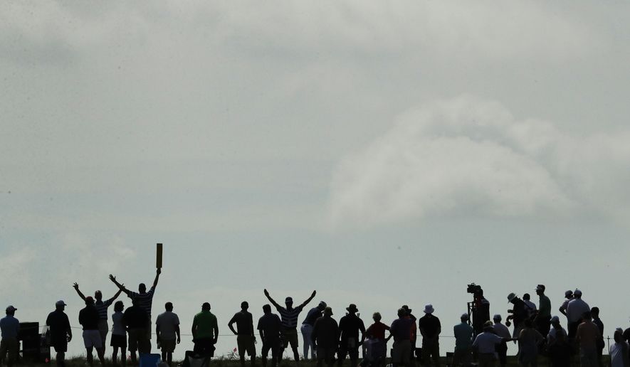 Fans watch on the fifth green during the first round of the U.S. Open golf tournament Thursday, June 15, 2017, at Erin Hills in Erin, Wis. (AP Photo/Charlie Riedel)