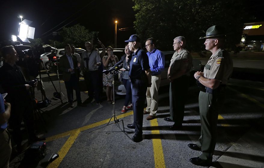 Tennessee Bureau of Investigation Director Mark Gwyn, center, speaks during a news conference held at a truck stop Thursday, June 15, 2017, in Christiana, Tenn. The two escaped inmates sought in the killings of two guards on a Georgia prison bus were captured Thursday in Tennessee after holding an elderly couple captive and leading police on a chase by car and foot, authorities said. (AP Photo/Mark Humphrey)