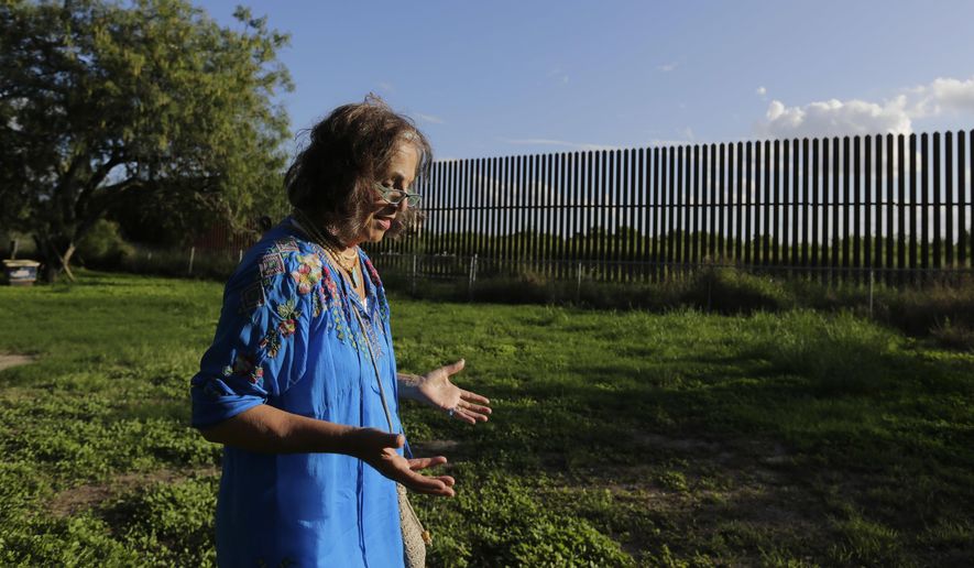 In this Sept. 17, 2015, photo, Dr. Eloisa Tamez walks in her backyard where the border fence passes through her property, in San Benito, Texas in the Rio Grande Valley. Tamez refused to cede her three acres in San Benito for the building of the wall, land that had been in her family for generations. A federal judge ruled in the government's favor, and Tamez was compensated $56,000. With the looming prospect of a long and drawn-out fight over a proposed U.S.-Mexico border wall, government lawyers are taking new action to close the last cases against landowners over the existing border fence. (AP Photo/Eric Gay)