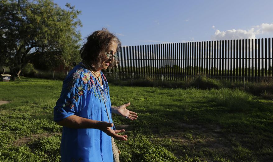 In this Sept. 17, 2015, photo, Dr. Eloisa Tamez walks in her backyard where the border fence passes through her property, in San Benito, Texas in the Rio Grande Valley. Tamez refused to cede her three acres in San Benito for the building of the wall, land that had been in her family for generations. A federal judge ruled in the government's favor, and Tamez was compensated $56,000. With the looming prospect of a long and drawn-out fight over a proposed U.S.-Mexico border wall, government lawyers are taking new action to close the last cases against landowners over the existing border fence. (AP Photo/Eric Gay)