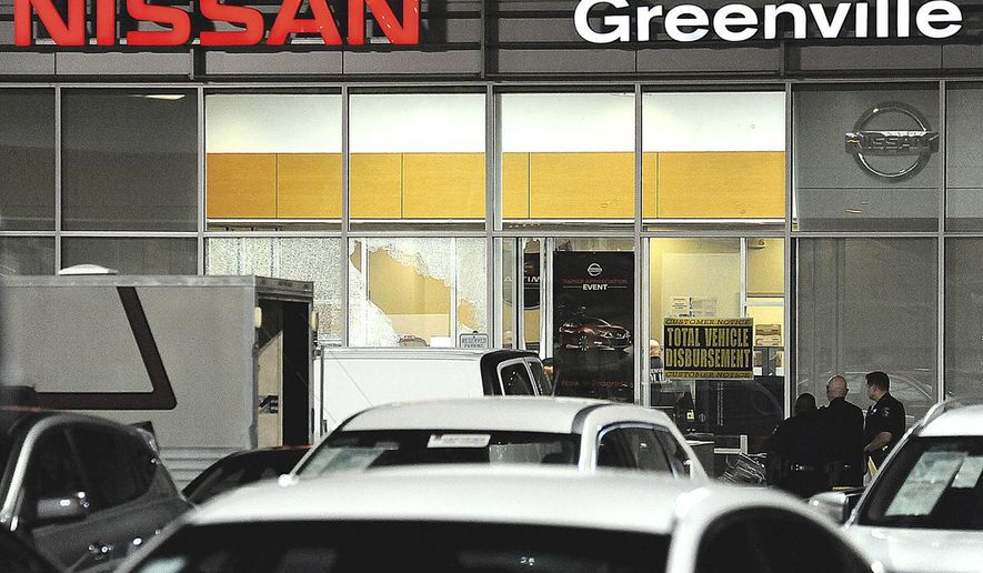 FILE - In this May 30, 2017 file photo, police gather at the scene of a deadly shooting at a car dealership in Greenville, Texas. Two bounty hunters killed in a point-blank shootout with a fugitive at the dealership were offered $3,000 to apprehend the felon. A police report obtained by The Dallas Morning News shows private investigators Fidel Garcia Jr. and Gabriel Bernal would have collected the payout if they took 49-year-old Ramon Michael Hutchinson into custody. (David Claybourn/The Herald-Banner via AP File)