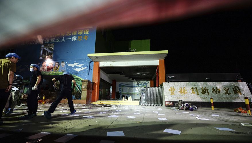 In this photo released by China's Xinhua News Agency, investigators work early Friday, June 16, 2017, at the scene of an explosion outside a kindergarten in Fengxian County in eastern China's Jiangsu Province. Several people were killed and dozens more injured in an explosion Thursday at the front gate of the kindergarten in eastern China as relatives were picking up their children at the end of the school day, local officials said. (Li Xiang/Xinhua via AP)