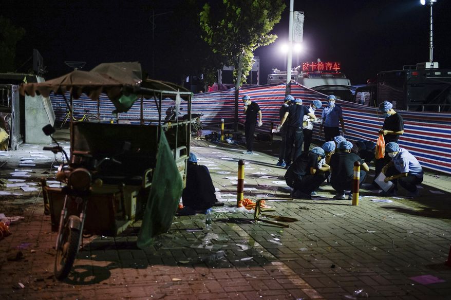 In this photo released by China's Xinhua News Agency, investigators work early Friday, June 16, 2017, at the scene of an explosion outside a kindergarten in Fengxian County in eastern China's Jiangsu Province. Several people were killed and dozens more injured in an explosion Thursday at the front gate of the kindergarten in eastern China as relatives were picking up their children at the end of the school day, local officials said. (Li Xiang/Xinhua via AP)