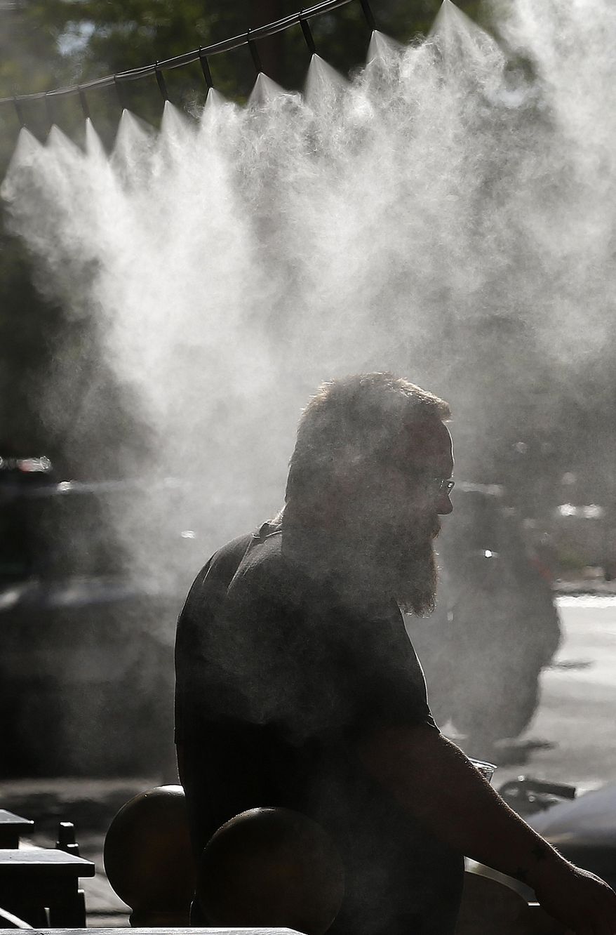Misting machines spray cool water on a patron at a restaurant as temperatures climb to 110-degrees Thursday, June 15, 2017, in Phoenix. Temperatures are expected to hit 120-degrees in the next week. (AP Photo/Ross D. Franklin)