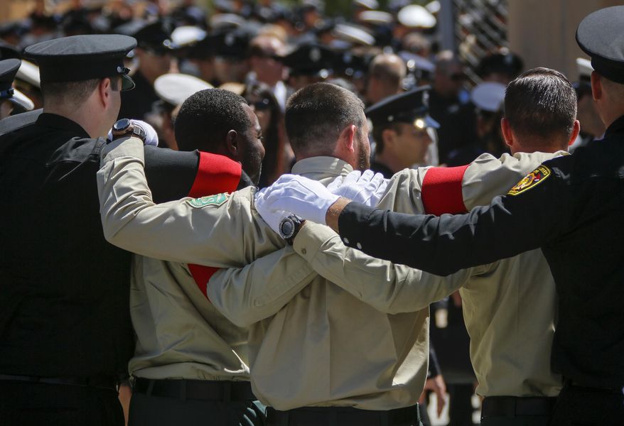 Firefighters gather for hugs and photographs after attending the funeral for fallen Firefighter Kelly Wong at the Cathedral Of Our Lady Of Angels, Friday, June 16, 2017 in Los Angeles. The 29-year-old Wong fell from the ladder on June 3 and died two days later. (Mark Boster /Los Angeles Times via AP)