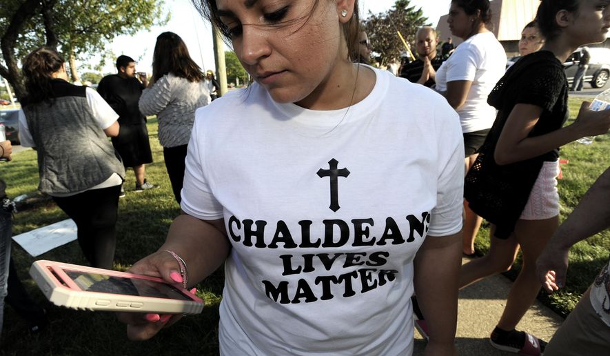 Astevana Shaya, 28, of Sterling Heights, Mich., wears a Chaldeans Lives Matter T-shirt at the protest, Monday, June 12, 2017 in Sterling Heights, Mich. The arrests of dozens of Iraqi Christians in southeastern Michigan by U.S. immigration officials appear to be among the first roundups of people from Iraq who have long faced deportation, underscoring rising concerns in other immigrant communities. (Todd McInturf/Detroit News via AP) /Detroit News via AP)