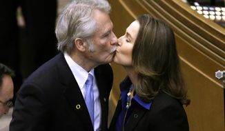 FILE - In this Jan. 12, 2015 ,file photo, Oregon Gov. John Kitzhaber kisses fiancee, Cylvia Hayes, after he is sworn in for an unprecedented fourth term as governor in Salem, Ore. Federal authorities said Friday, June 16, 2017, after a two year investigation, that no criminal charges will be brought against Kitzhaber and Hayes. (AP Photo/Don Ryan, File)