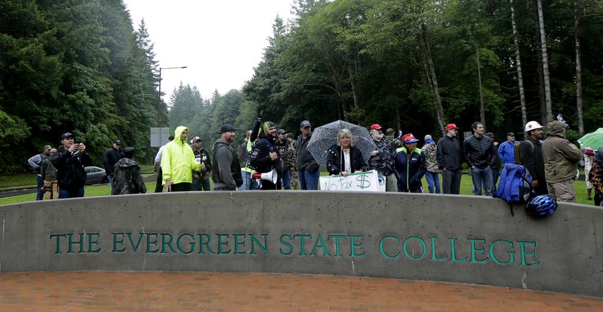 Protesters with the conservative group Patriot Prayer gather next to a sign at the main entrance to Evergreen State College, Thursday, June 15, 2017, in Olympia, Wash. The group later marched to an open square on campus and confronted counter-protesters. (AP Photo/Ted S. Warren)