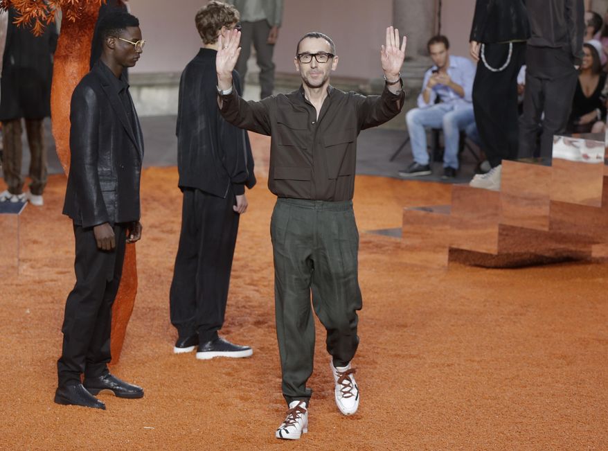 Fashion designer Alessandro Sartori waves at the end of the presentation of the Ermenegildo Zegna men's Spring-Summer 2018 collection, in Milan, Italy, Friday, June 16, 2017. (AP Photo/Luca Bruno)