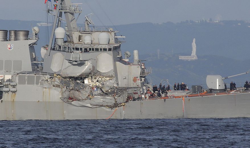 The damaged USS Fitzgerald is seen near the U.S. Naval base in Yokosuka, southwest of Tokyo, after the U.S. destroyer collided with the Philippine-registered container ship ACX Crystal in the waters off the Izu Peninsula Saturday, June 17, 2017. Crew members from the destroyer USS Dewey were helping stabilize the damaged USS Fitzgerald after its collision off the coast of Japan before dawn Saturday, leaving seven sailors missing and at least three injured. (AP Photo/Eugene Hoshiko)