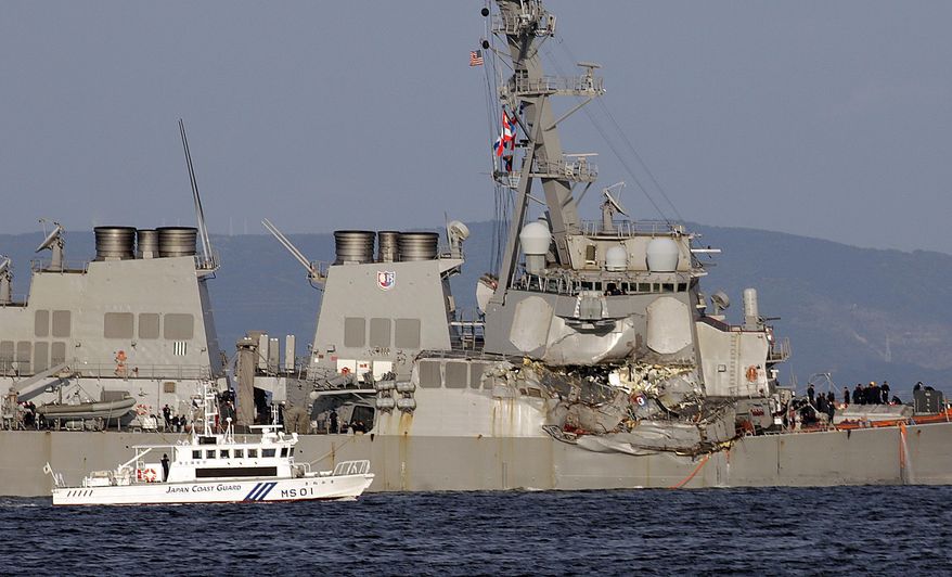 A Japan Coast Guard baot goes along with the damaged USS Fitzgerald near the U.S. Naval base in Yokosuka, southwest of Tokyo, after the U.S. destroyer collided with the Philippine-registered container ship ACX Crystal in the waters off the Izu Peninsula Saturday, June 17, 2017. Crew members from the destroyer USS Dewey were helping stabilize the damaged USS Fitzgerald after its collision off the coast of Japan before dawn Saturday, leaving seven sailors missing and at least three injured. (AP Photo/Eugene Hoshiko)