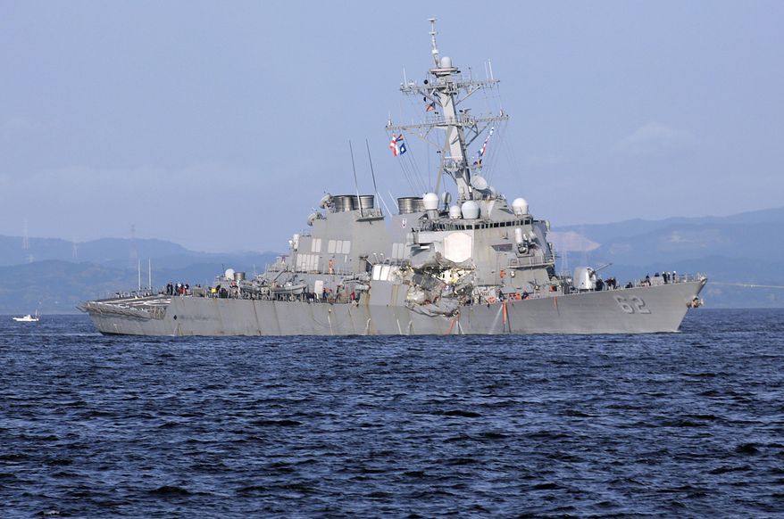 The damaged USS Fitzgerald is seen near the U.S. Naval base in Yokosuka, southwest of Tokyo, after the U.S. destroyer collided with the Philippine-registered container ship ACX Crystal in the waters off the Izu Peninsula Saturday, June 17, 2017. Crew members from the destroyer USS Dewey were helping stabilize the damaged USS Fitzgerald after its collision off the coast of Japan before dawn Saturday, leaving seven sailors missing and at least three injured. (AP Photo/Eugene Hoshiko)