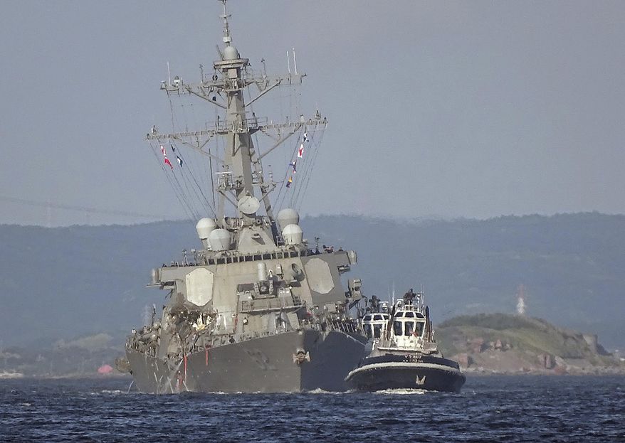 The damaged USS Fitzgerald is being towed by a tugboat in the waters near the U.S. Naval base in Yokosuka, southwest of Tokyo, after the U.S. destroyer collided with the Philippine-registered container ship ACX Crystal in the waters off the Izu Peninsula Saturday, June 17, 2017. Crew members from the destroyer USS Dewey were helping stabilize the damaged USS Fitzgerald after its collision off the coast of Japan before dawn Saturday, leaving seven sailors missing and at least three injured. (AP Photo/Eugene Hoshiko)