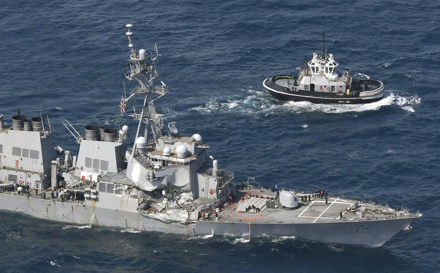 The USS Fitzgerald, left, heads to Yokosuka, home base of the 7th Fleet, beside a U.S. tugboat, off Shimoda, Shizuoka prefecture, Japan, after the Navy destroyer collided with a merchant ship, Saturday, June 17, 2017. The U.S. Navy says the USS Fitzgerald suffered damage below the water line on its starboard side after it collided with a Philippine-flagged merchant ship. (Iori Sagisawa/Kyodo News via AP)
