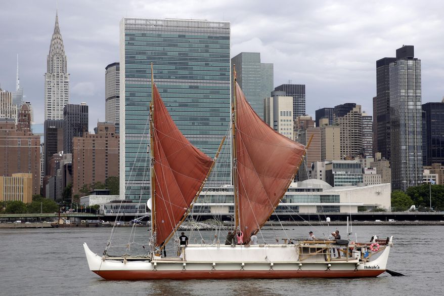 FILE--In this June 8, 2016, file photo, the traditional Polynesian voyaging canoe Hokulea, on an around-the-world journey, sails by the United Nations on New York's East River, during the World Oceans Day observance. The Polynesian voyaging canoe is returning to Hawaii after a three-year journey around the world guided only by nature with navigators using no modern navigation to guide Hokulea across 40,000 nautical miles to 19 countries.Thousands are expected to welcome the double-hulled canoe to Oahu, Hawaii, on Saturday, June 17, 2017. (AP Photo/Richard Drew, file)